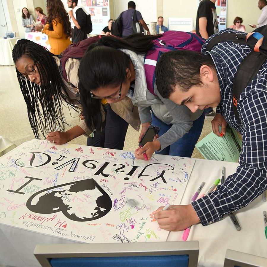 学生们在多元心海报上签名.